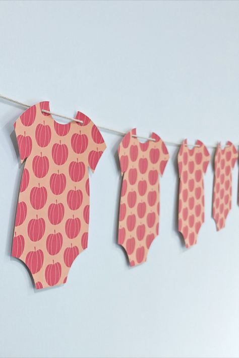 Celebrate your new arrival with this pink pumpkin themed garland decoration. This garland consists of 9 onesie cardstock cutouts on twine. Onesie Garland, Pumpkin Gender Reveal, Pumpkin Onesie, Baby Shower Garland, Garland Decoration, Girl Gender Reveal, Halloween Onesie, Pink Pumpkin, Pumpkin Baby