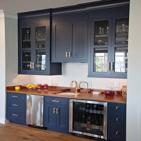 Navy blue kitchen wet bar, fitted with shaker cabinets painted Benjamin Moore Hale Navy and accented with brass pulls, features wood countertops holding a sink with a brass gooseneck faucet flanked underneath by a stainless steel mini fridge and a glass front wine fridge while above glass front china cabinets flank slight smaller close cabinet doors. Dark Blue Kitchen Cabinets, Wet Bar Cabinets, Navy Blue Kitchen Cabinets, Dark Blue Kitchens, Kitchen Wet Bar, Navy Cabinets, Counter Kitchen, Navy Blue Kitchen, Navy Kitchen