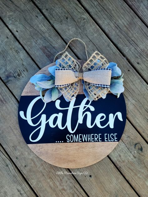 "Welcome your guests, or not with this funny Welcome Door Hanger Sign 3 Sizes available 14\" 16\" 18\" Wood round sign each handmade with a stain background, Black strip, with 3D Gather wording, painted \"....SOMEWHERE ELSE\". All topped off with a beautiful two layered farmhouse bow and greenery. Great for Home decor, Gift for her, All year round wreath decor, House Warming Gift, Realtor Gift and more!" Gather Somewhere Else Sign, Gather Door Hanger, Navy Door Hanger, Sassy Door Signs, Door Hanger Sayings, Welcome Sign Front Door Funny, Front Door Signs Funny, Welcome Ish Sign Front Door, Round Welcome Sign Front Door Diy