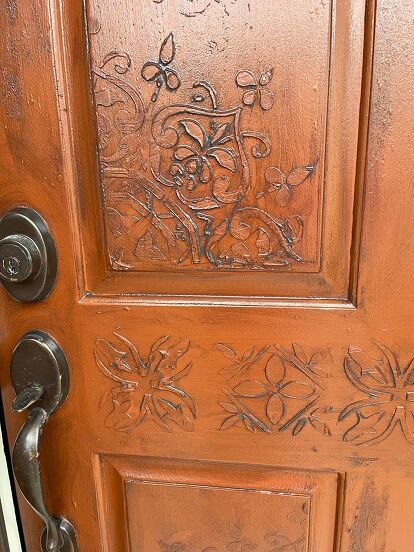 I have been wanting to do something with my front door for a while. So, I finally had the time and good weather to be able to leave the door open for a few hours. I had bought some stencils I wanted to use to create a "raised" design since I couldn't have a "carved" one. This is the before. I had painted my door a long time ago with an exterior reddish brown color which I still loved as my background. This is the after. If you like this, follow along so that you can see how I did… Front Door Stencil Ideas, Door Stencil, Stenciled Doors, Entry Patio, Timber Front Door, Leave The Door Open, Orange Front Doors, Secret Doors, Furniture Reupholstery