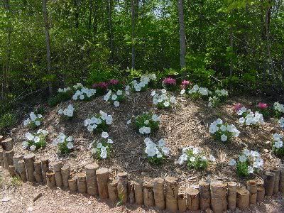 fieldstone flower bed edging #flowerbedideas Log Flower Bed, Concrete Yard, Log Ideas, Flower Bed Borders, Outdoor Studio, Playhouse Ideas, Log Planter, Flower Bed Edging, Playground Ideas