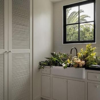 Laundry Room Double Doors Design Ideas Louvered Cabinet Doors, Farmhouse Sink With Black Faucet, Sink With Black Faucet, Louvered Bifold Doors, White Wash Wood Floors, Black Sink Faucet, River Rock Floor, Arabesque Tile Backsplash, White Quartzite Countertops