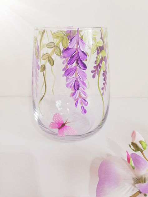 The stemless glass has been hand painted with glass enamel in an eye catching wisteria design in a choice of either purple or burgundy.with soft flowing leaves and swirls. The glass style is so versatile, it can be used as a glass for your favourite drink, a pretty tealight holder, a small vase or all three as its dishwasher friendly. It has been baked in the oven to seal and is top drawer dishwasher safe.. The glass stands at 12.5cm high and holds 590ml. Lavender Glass Painting, Flower Bottle Painting, Candles Painting Ideas, Candle Jar Painting, Small Jar Crafts, Jar Art Paint, Glass Painting Aesthetic, Glass Jar Painting Ideas, Glass Vase Painting Ideas