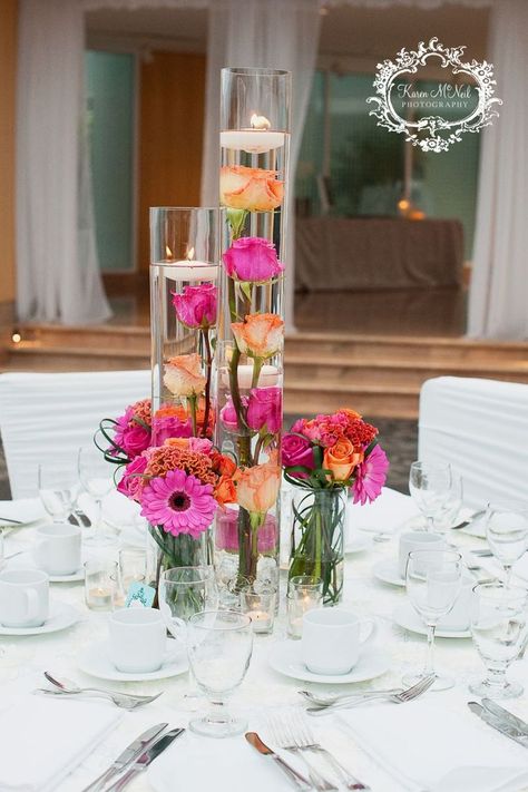 Spring Head Table Wedding, Decor For Round Tables Wedding, Colorful Candle Centerpieces, Flowers Candles Centerpiece, Pink Orange Decorations, Pink Orange Yellow Wedding Centerpieces, Fuschia Orange Wedding, Orange And Pink Wedding Theme, Floating Candles Wedding Centerpieces