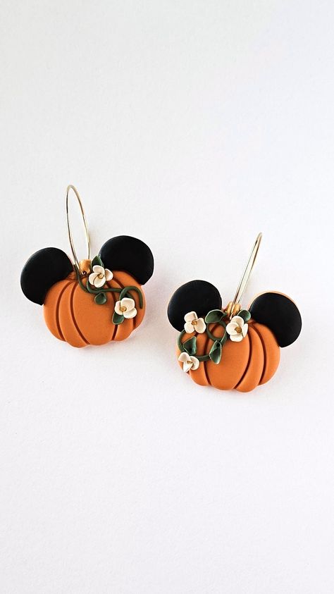 Handmade polymer clay hoop earrings featuring a magical pumpkin design with mouse ears, adorned with botanical flowers, capturing the essence of fall and autumn. Disney Clay Earrings Diy, Polymer Clay Fall Ideas, Pumpkin Polymer Clay Earrings, Disney Polymer Clay Earrings, Halloween Earrings Diy, Pumpkin Clay Earrings, Fall Polymer Clay Earrings, Halloween Clay Earrings, Pumpkin Clay