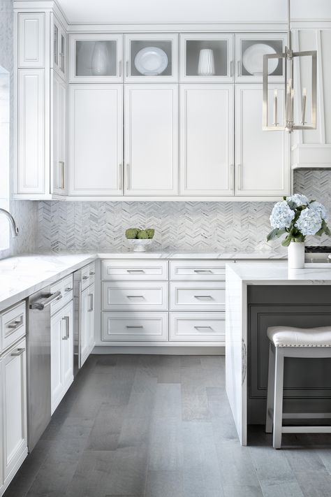 Large farmhouse u-shaped medium tone wood floor with an undermount sink, recessed white panel cabinets against a gray stone tile backsplash, with stainless steel appliances, and a large white quartz island. Grey Kitchen Floor, Gray And White Kitchen, Modern Farmhouse Kitchen, White Kitchen Design, Grey Flooring, White Countertops, Grey Kitchens, Modern Farmhouse Kitchens, White Kitchen Cabinets