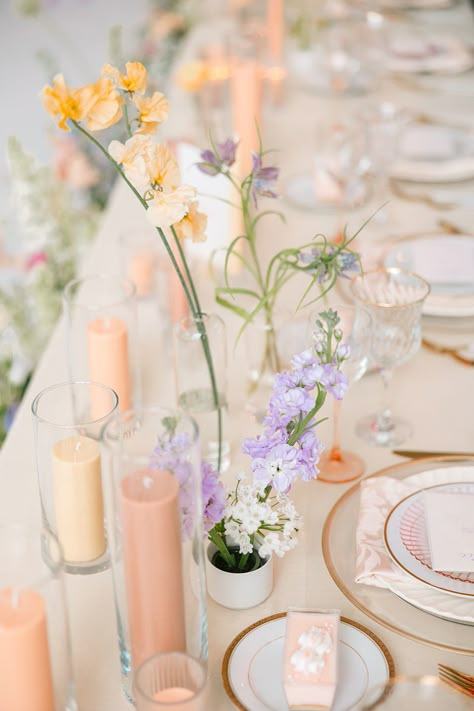 Soft peach, blush, pink, lavender, and white flowers made a subtle statement in these bud vases for the wedding table centerpieces. Gold rimmed china and personalized cheesecakes added that extra sweet touch to the look! More head table ideas here. Peach And Lavender Wedding Table, Wedding Theme Lilac, Subtle Color Wedding, Lavender Peach And Honey Wedding, Peach And Lilac Wedding Flowers, Lavender And Peach Wedding Decor, Pink Peach Lavender Wedding, Pastel Wedding Table Setting, Gold And Lavender Wedding