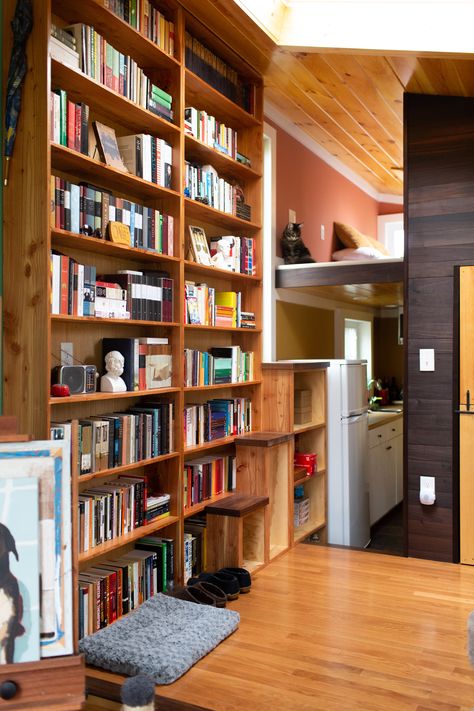 Upon entering, the first thing you see are the grand, floor-to-ceiling bookshelves. "The reclaimed redwood bookshelves were custom built by by Ben, and are the prominent feature of the house." Tiny House Library, Tiny House Design Small Cottages, Tiny House Storage Ideas, Floor To Ceiling Bookshelves, Living Room Photos, Small Apartment Decorating, Custom Storage, Tiny House Interior, Tiny Apartment