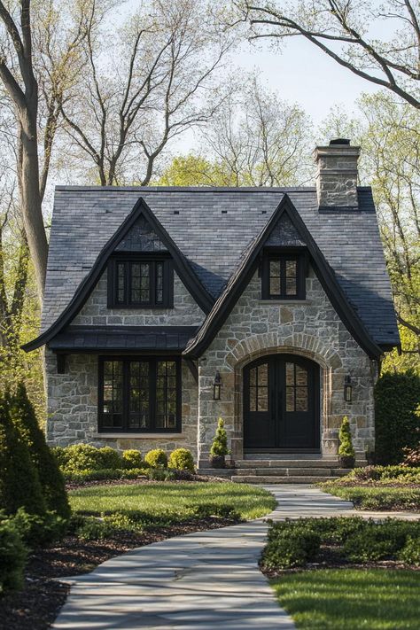 Modern gothic style cottage facade with gabled slate roof farmhouse landscape. Check out all of these modern gothic-style cottages that blend dark elegance and contemporary flair to create stunning exteriors. Gothic Tiny House Plans, Styles Of Homes Architecture, French Country Cottage Exterior, European Cottage Exterior, Shingle House Exterior, Gothic Tiny House, Cottage Facade, French Stone House, Stone Cottage Homes