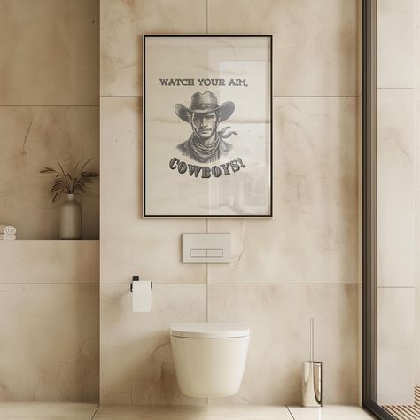 Meet our vintage cowboy bathroom decor "Watch your aim". This western humorous toilet sign will leave you and your guest chuckling every time! Textured wall art! --- ☞ More bathroom & toilet prints: https://www.etsy.com/au/shop/FunkyWallsStudio?ref=seller-platform-mcnav&section_id=48507718 DIGITAL FILE SIZES INCLUDED: 1:1 Ratio, 2:3 Ratio, 3:4 Ratio, 4:5 Ratio, 5:7 Ratio, 11x14in ( see photo for ratio shrinking and enlargement without distorting the proportions) ☞ After purchasing this artwork y Vintage Cowboy Bathroom, Cowboy Bathroom Decor, Wc Poster, Toilet Prints, Cowboy Bathroom, Cowboy Cabin, Bathroom Signage, Toilet Wall Art, Branding Signage