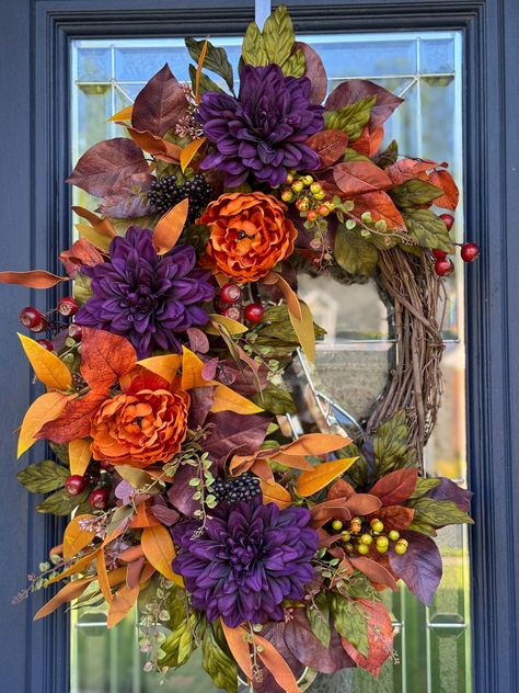 This richly colored oval Autumn wreath features deep purple dahlias and beautiful rust peonies.  The coppery brown, moss green and rust foliages surround the blooms and you'll also find purple berries and deep red crater berries.   This wreath would be a beautiful fall welcome on your front door, hanging above your mantle or the buffet in your dining room.  Wreaths make wonderful gifts as well! ️I recommend hanging your wreath in a well covered area away from the elements and direct sunlight. Me Purple Fall Wreath, Purple Dahlias, Wreaths Design, Purple Berries, Fall Bathroom, Fall Wreath For Front Door, Purple Dahlia, Orange Wreath, Copper Decor