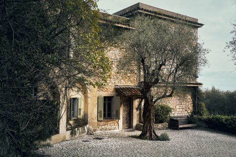 The exterior of Picasso's final home in Mougins, located in the French Riviera. The rustic stone house features green shutters, a cobblestone courtyard, and is surrounded by lush foliage and an olive tree, reflecting the serene and picturesque setting where Picasso spent the last years of his life. Rustic Stone House, Green Shutters, Tech Art, Rustic Stone, House Features, The French Riviera, Event Exhibition, Lasting Love, Stone House