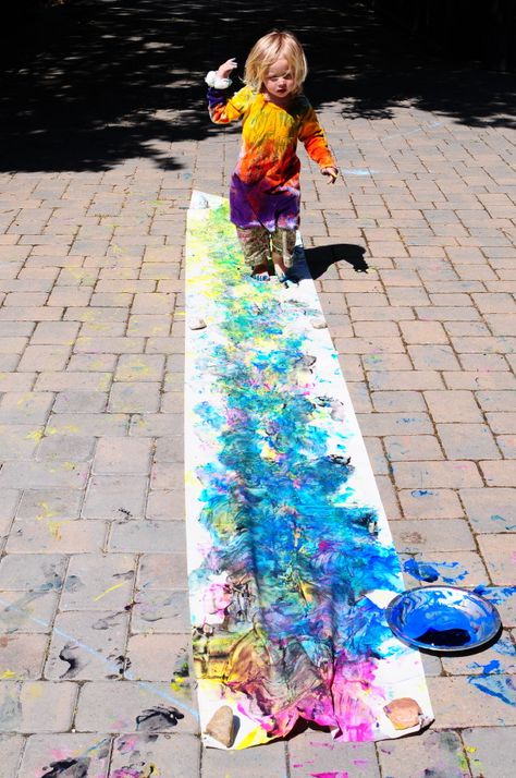 This was an easy summer project, we put out pie plates full of paint in different colors and unrolled some cheap roll paper from IKEA, holding it down with rocks. Oh, and warned the kids that it was going to be slippery, please dont crack your skulls open on the <!-- //LinkWithinCodeStartvar linkwithin_site_id = 1724895;var linkwithin_div_class = "linkwithin_hook";//LinkWithinCodeEnd --> Walking Feet Craft, Community Painting, Child Art, Fun Crafts To Do, Summer Crafts For Kids, Outdoor Crafts, Roll Paper, Foot Print, Group Art