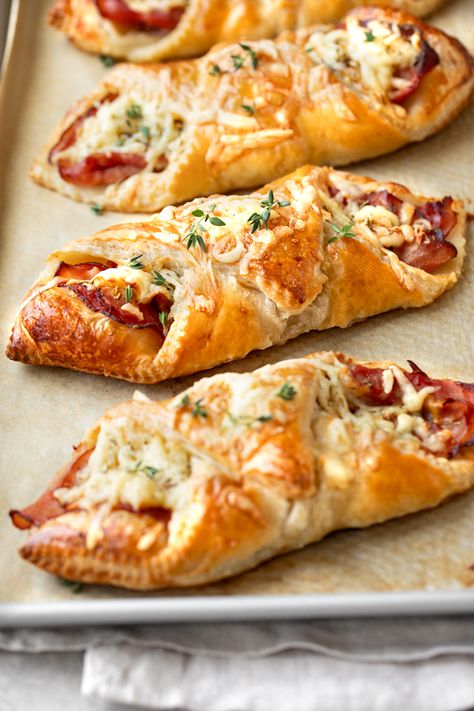 These warm, flaky ham and cheese croissants are easy to prep at home, and make for a delicious cafe-inspired meal with a crisp green salad! | thecozyapron.com #hamandcheesecroissants #hamandcheesecroissantsrecipe #hamandcheesecroissantsbaked #hamcheesecroissants #hamandcheesecroissantspuffpastry Easy Ham And Cheese Croissant, Ham And Cheese Croissant Roll Ups, Croissant Grilled Cheese, Ham And Cheese Croissants, Puff Pastry Croissant, Croissant Roll, Ham And Cheese Croissant, Fun Apps, Cheese Croissant