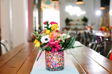 Quirky Table Centerpieces, Pride Wedding Decorations, Simple Colorful Centerpieces, Sprinkle Flower Centerpiece, Colorful Centerpieces For Party, Artsy Centerpieces, Simple Colorful Wedding Centerpieces, Confetti Centerpiece, Colorful Floral Centerpieces