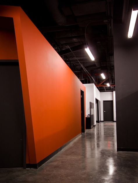 orange wall Orange And Black Painted Walls, Office With Orange Accents, Orange And Black Interior, Orange And Black Office, Home Office White Walls, Black Orange Aesthetic, Orange Accent Wall, Orange Gym, Office Wall Colors