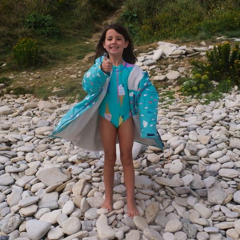 This UV-protective long sleeve swimsuit celebrates fun in the sun with a playful ice cream print on a summery turquoise background. Built to keep young explorers sunsafe, it offers UPF50+ sun protection with a high neck and full-length sleeves, shielding them from UVA and UVB rays. Made with 80% recycled nylon from recycled fishing nets and 20% spandex, the fabric has the stretch and durability needed for hours of water play. Flatlock seams and quick-dry fabric enhance comfort while adjustable cuffs keep the arms in place. The handy front zip makes changing a breeze, leaving more time for beach games and swimming sessions. Machine washable and made to last, this girls swimming costume is built for season after season of unforgettable splash-filled adventures.