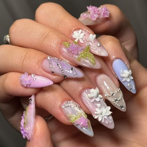 🌸💜 "Lavender Dreams" Press-On Nail Set by Jerry Nails 🌸💖 Dive into the enchanting world of our "Lavender Dreams" Press-On Nail Set, a perfect blend of elegance and whimsy crafted for those who love a touch of fantasy in their fashion. These nails are designed with meticulous attention to detail, making them a must-have for any occasion where you want to impress. 🎨 Artistic Highlights: 🌺 Mixed Floral Designs: Each nail is a canvas featuring a variety of floral designs in shades of lavender and white. The artistry is enhanced by the delicate placement of tiny blooms that seem to float on a dreamy backdrop. 🌿 Vivid Green Accents: Sprigs of green add a fresh touch to the floral arrangements, providing a lively contrast against the soft pastels. 💎 Elegant Bead Embellishments: Strategica Petals Nail Art, Tips Acrylic Nails, Nails Elegant, Nail Store, 3d Flower Nails, Nail Board, Elegant Garden, Nail Art Gel, London Nails