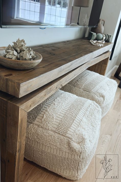 Poufs are a great way to add extra seating to your space. We love how these can easily slip under this console table! Table With Poufs Under, Console Table With Poufs, Console Table With Ottomans Under Tv, Ottoman Under Tv, Ottoman Under Console Table, Console Table With Ottomans, Black Leather Living Room Furniture, Small Ottomans, Entry Table Decor