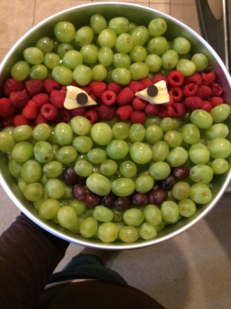 A ninja turtle fruit tray I made for my nephews bday.. I used a large cake pan did 2 layers of grapes and raspberries, then cut bananas for the eyes with chocolate chips for the pupils. ^.^ easy peasy... It took 1 box of SAMs club green grapes and 1 box of Sams raspberries. A few dark grapes and 1/2 a bananas.. ^.^ (I woulda done better on the eyes of i had more time! This was last min! Lol) #ninjaturtle #tmnt #party #fruittray #boys #birthday Ninja Turtle Fruit Tray, Easy Ninja Turtle Cake, Tmnt Party Food, Turtle Fruit, Halloween Fruit Tray, Fruit Tray Ideas, Kindergarten Snacks, Ninja Turtle Invitations, Ninja Turtle Birthday Cake