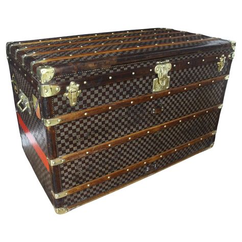 This superb Louis Vuitton steamer trunk features the very sought after checkers canvas, all leather chocolate color trim, LV stamped solid brass locks and studs as well as solid brass side handles and brass corners. Its customized hand painted red stribes as well as its few traveling labels add a touch of personality. It has got a beautiful original patina and is very elegant. It is the largest trunk ever produced by Louis Vuitton and it is very impressive. All its interior has been completely r Louis Vuitton Trunks, Leather Couches Living Room, Trunk Table, Leather Couches, Louis Vuitton Trunk, Brass Corners, Decoration Pieces, Vintage Trunks, Steamer Trunk