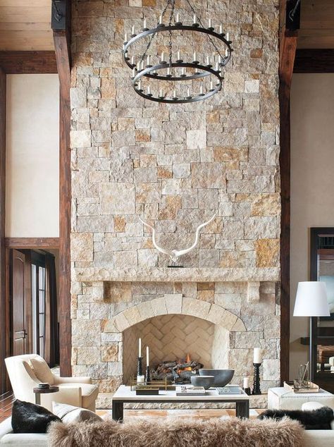 a neutral farmhouse living room with a stone fireplace, elegant creamy furniture and a statement chandelier Ski Lodge Fireplace, Low Fireplace, Whitewash Stone Fireplace, Lodge Fireplace, Chalet Living Room, Fireplace Wedding, White Stone Fireplaces, Monochromatic Living Room, Limestone Fireplace Surround