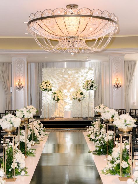 The couple celebrated their nuptials surrounded by a timeless palette of white, gold and black. “Our wedding was very classic; white flowers, gold touches and a mixture of dark effects from the ZaZa Phantom Ballroom flooring,” notes the bride. | Photo: Stephania Campos Photography | black aisle runner, white flower wall, tall white florals #weddingdecor #ceremonydecor #weddingflowers #floraldesign #gold #black #white #weddingphotography #weddingideas #luxurywedding #elegantwedding White And Gold Wedding Ceremony Aisle Decorations, Flower Wall White And Gold, Black White And Gold Wedding Ceremony, Classic Wedding Ceremony Decor, Chapel Decorations Wedding, White And Gold Wedding Ceremony, Black Classic Wedding, Elegant Wedding Aisle, Black Aisle Runner