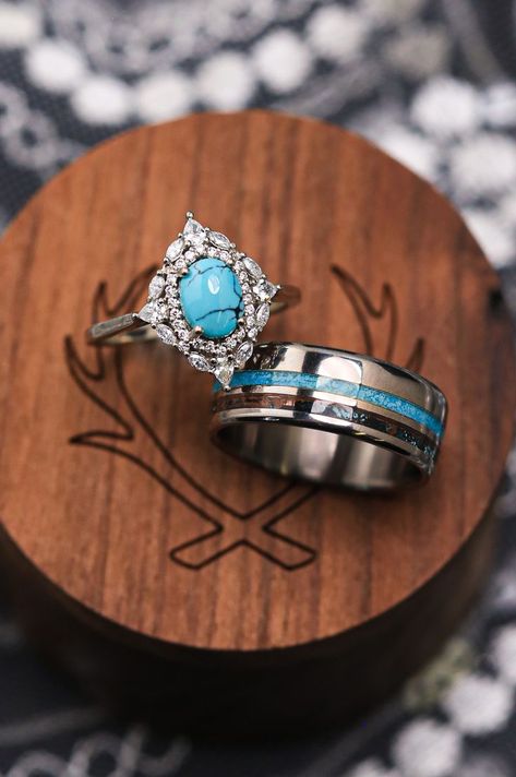 A turquoise wedding ring set from Staghead Designs sits on a ring box. This ring set features a modified version of our "North Star" 14K white gold engagement ring with a diamond halo & turquoise center stone as well as our "Castor" wedding band in titanium with crushed turquoise & patina copper inlays. These fully customizable rings can be made with a variety of unique stones & materials like salt & pepper diamond, whiskey barrel oak, antler, Montana sapphire, etc. Western Turquoise Wedding Ring, Western Engagement Rings Turquoise Wedding Bands, Unique Sterling Silver Turquoise Wedding Ring, Western Style Turquoise Ring With Inlay, Western Engagement Rings Turquoise Sterling Silver, Western Engagement Rings, Copper Wedding Band, Western Wedding Rings, Turquoise Wedding Rings