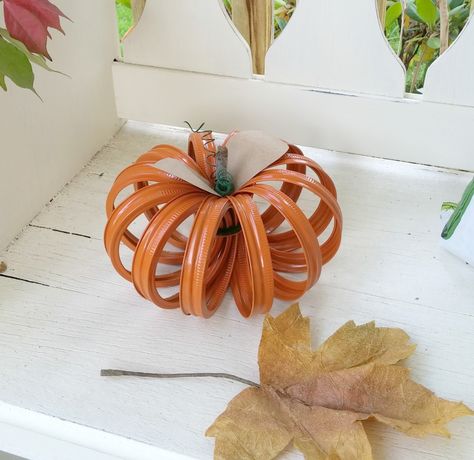 How to make a super cute pumpkin from canning jar rings! Ring Storage Ideas, Jar Ring Pumpkin, Canning Lid Pumpkin, Canning Ring Pumpkin, Canning Jars Crafts, Mason Jar Lids Crafts, Jar Lid Crafts, Coffee Shelf, Fall Pumpkin Decor