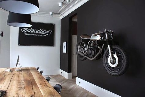 Motorcycle wall mount, matte black painted wall, wood table Cave Decorations, Black Painted Walls, Vibeke Design, Masculine Decor, Motorcycle Decor, Motorcycle Garage, Cafe Racer Bikes, Man Caves, Painted Wall