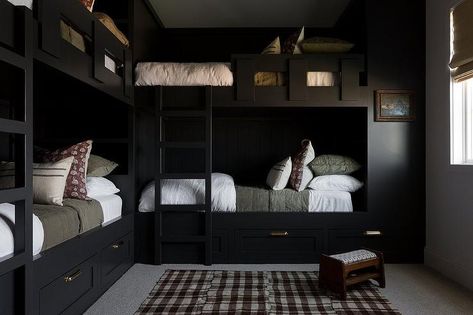 Bedroom features L shaped black built in bunk beds with forest green bedding, a black bunk bed ladder and a brown gingham rug with small wooden stool. Moody Lake House, Black Lake House, Black Bunk Beds, L Shaped Bunk Beds, Bunk Bed Ladder, Bunk Beds Built In, Light And Dwell, Built In Bunks, Bunk Rooms