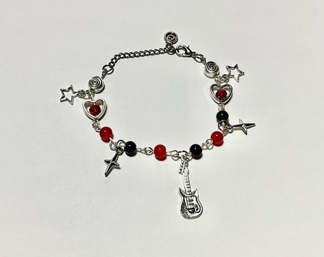 Grunge Rock Charm Bracelet with Guitar, Stars, and Heart Accents 🎸🖤 ~ ˚　　　　✦　　　.　　. 　 ˚　.　　　　　 . ✦　　　 　˚　　　　 . ★⋆. ࿐࿔ 　　　.   　　˚　　 　　*　　 　　✦　　　.　　.　　　✦　˚ 　　　　 ˚　.˚　　　　✦　　　.　　. 　 ˚　.　　　　 　　 　　　　 ੈ✧̣̇˳·˖✶ Tags: #rockjewelry #punkstyle #grungeaccessories #charmbracelets #bracelets #edgyfashion #guitarcharm #rockinspired #bracelet #FashionJewelry, #jewelry #grunge #handmadejewelry #darkaesthetic #boldjewelry #red #black #goth #gothbracelet #y2k #y2kbracelet #y2kcharmbracelets #y2kcharmbracelet... Grunge Bracelets, Alt Jewelry, Jewelry Grunge, Grunge Accessories, Bracelet Stacks, Bracelets Ideas, Rock Jewelry, Black Goth, Bold Jewelry