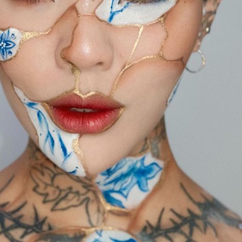 Mei Pang on Instagram: "Probably one of my favourite looks to date 🥹 Kintsugi roughly translates as ‘joining with gold’. It is a centuries-old Japanese repair technique which uses a lacquer dusted with powdered gold to restore broken ceramic and porcelain vessels. I’ve been loving incorporating my tattoos to my makeup so this look makes me so happy! • • @mehronmakeup metallic powder (gold) @makeupforever tan lip liner (to outline) @mehronmakeup blue paradise paint @colourpopcosmetics fade into hue palette (for shading) @desioeyes @desiolens wild green contact @kaleidosmakeup smeared rouge liquid lipstick #kintsugi #avantgardemakeup #editorialmakeup #experimentalmakeup" Anti Surveillance Makeup, Porcelain Makeup Look, Kintsugi Photography, Kintsugi Makeup, Mei Pang Makeup, Kintsugi Painting, Painting Tattoo Ideas, Face Painting Designs Creative, Face Paint Art