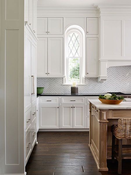 White kitchen with herringbone tile backsplash and a light wood island Herringbone Kitchen Backsplash, White Traditional Kitchen, Herringbone Kitchen, Kitchen Design Color, Wood Island, Traditional Kitchen Design, Kabinet Dapur, Dark Floors, Wood Kitchen Cabinets