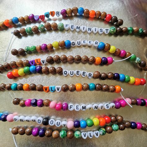 Rainbow colourful queer feminist wood bracelets accessories on a golden surface Queer Crafts, Queer Jewelry, Queer Outfits, Wood Bracelet, Craft Night, Bracelet Ideas, Accessories Bracelets, Friendship Bracelets, Diy Gifts