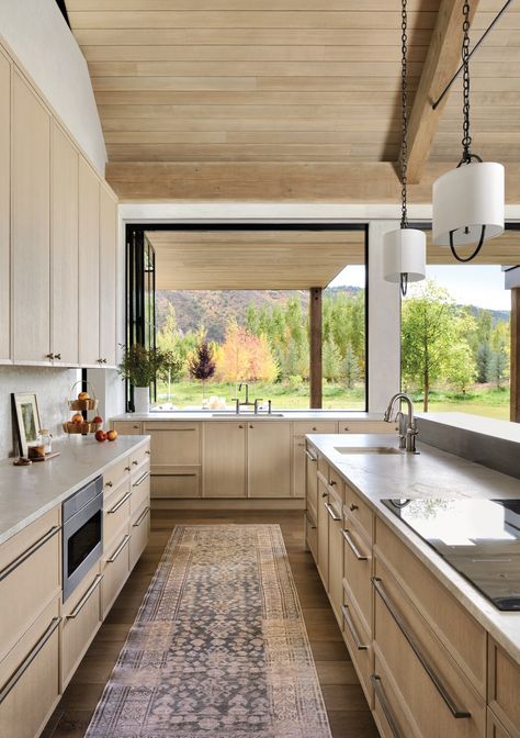 An accordion window in the kitchen opens to an exterior grilling area. Blonde-stained cabinets mimic the hue of the ceiling’s vertical-grain hemlock paneling, which continues onto the patio’s overhang for a seamless look. The runner is from Jaipur Living. Outside Breakfast, Kitchen Servery, Design Architect, Architecture Home, Jaipur Living, Galley Kitchen, Interior Kitchen, Colorado Homes, Ranch Style Home