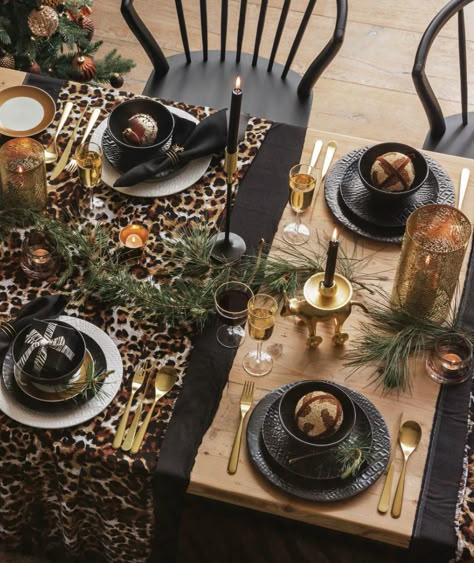 Bring together animal print fabrics with black, white and gold for a characterful take on Christmas dining. Use patterned runners to demarcate your place settings and accessorise with a few festive sprigs of fir.   From Amara  Click for more stylish Christmas table settings. Leopard Print Table Setting, Animal Print Table Setting, Animal Print Table Decor, Leopard Table Setting, Black And Gold Christmas Table Decor, Black Christmas Table, Black And Gold Christmas, African Christmas, Chirstmas Decor