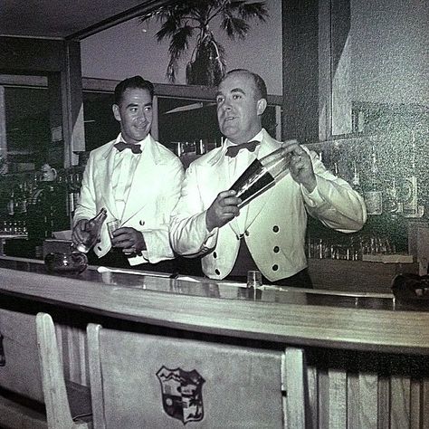 Early 1950's, two bartenders showing off their skills at the Shadow Mountain Clubhouse. Check out the Shadow Mountain Crest on the back of the chairs. Vintage Bar Outfit, 1940s Bartender, 1950s Speakeasy, 1920s Bartender, 1950s Bar, Bartender Uniform, Don Perignon, Bartender Outfit, White Cocktails