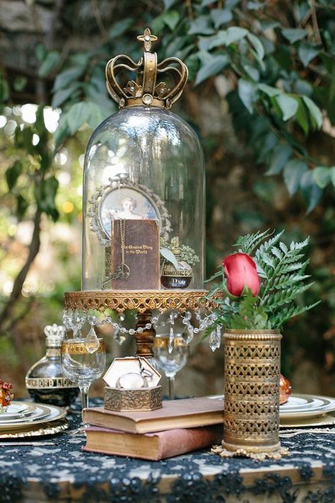 a cloche with a vintage book, key, a perfume and a framed portrait with a crown on top Dark Romance Wedding, Snow White Wedding, Casa Disney, Cloche Decor, Wedding Table Designs, Romance Wedding, Glass Cloche, Romantic Books, The Bell Jar