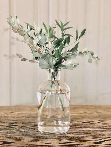 Greenery Bridal Shower Centerpieces, Bridal Shower In Green House, Simple Greenery Wedding Bouquet, Greenery Vase Centerpiece, Vine Centerpiece Wedding, Small Vase Centerpiece White, Glass Jar Table Centerpieces, Olive Leaf Wedding Centerpieces, Minimalist 30th Birthday Party