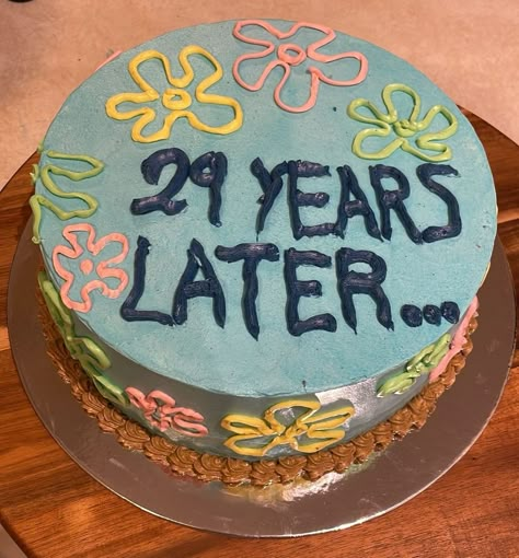 A cake covered in pale blue meringue, with the flowers of spongebob as background, it says "29 years later..." in dark blue letters Cake For 29th Birthday, Funny 29th Birthday Cake, 29 Cake Ideas, 29 Bday Cake, Birthday 29 Years Party Ideas, Birthday Cake 29 Years Old, 27 Bday Cake, 29th Birthday Ideas For Her Cake, 30 Year Old Birthday Cake