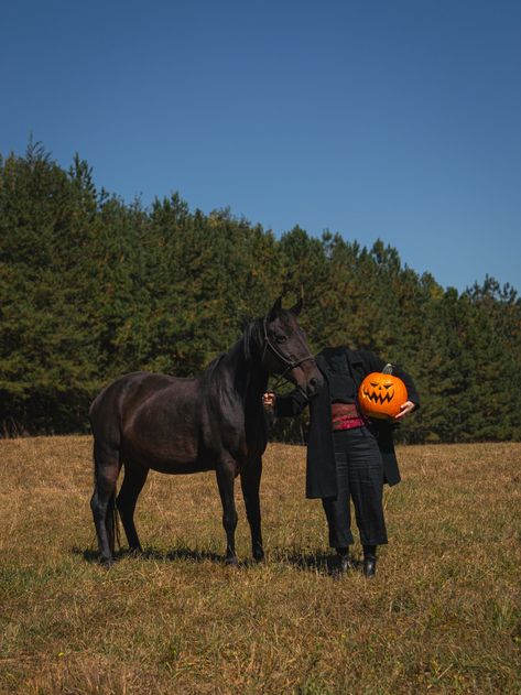 Headless figure stands with a jackolantern  under their arm next to a dark brown horse. The sky is cloudless blue over dead grass and green pine trees. Headless Horseman Photoshoot, Headless Horseman Costume, Headless Horseman, Couple Photoshoot, Couples Photoshoot, Photo And Video, Instagram Photos, Instagram Photo, Halloween