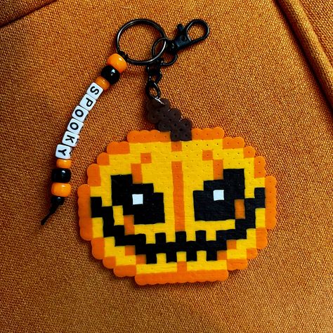 Halloween jack-o-lantern perler beaded keychain bag charm spooky accessories  Handmade black and orange pumpkin jack-o-lantern beaded keychain with pony beads and alpha beads that say SPOOKY  Perfect for backpack keys or purse bag charm  Tags, Halloween spooky scary pumpkins goth festive Kandi perler art fall jewelry accessories Makeup Perler Beads, Perler Bead Art Minecraft, Perler Bead Art Halloween, Fuse Beads Halloween, Alison Wonderland Perler, Halloween Hamma Beads, Horror Movie Perler Beads, Iron Bead Art, Kandi Perler Ideas