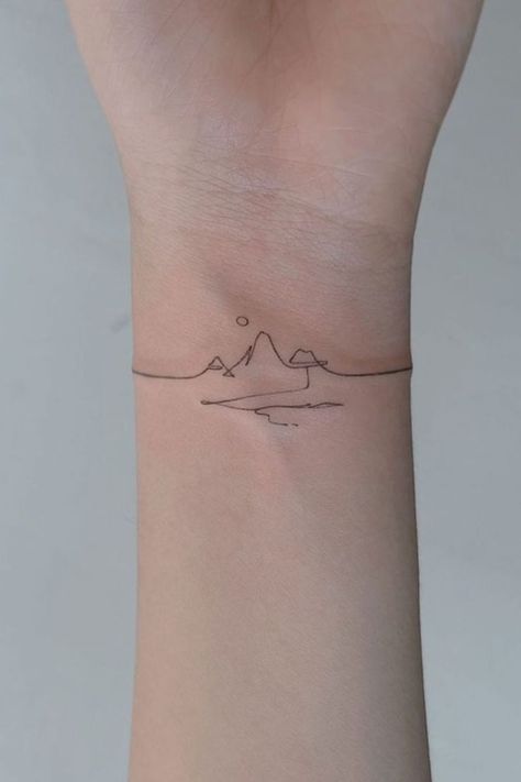 Line Art Landscape2 Minimalistic wrist tattoo featuring a fine line mountain range with a sun and a wave, representing nature and adventure. | Sky Rye Design Tattoos For Mountain Lovers, Mountain Line Art Tattoo, Mountain Tattoo On Wrist, Wrist Mountain Tattoo, Mountain Minimalist Tattoo, Nature Fine Line Tattoo, Mountain Fine Line Tattoo, One Line Mountain Tattoo, Mountain Wrist Tattoo