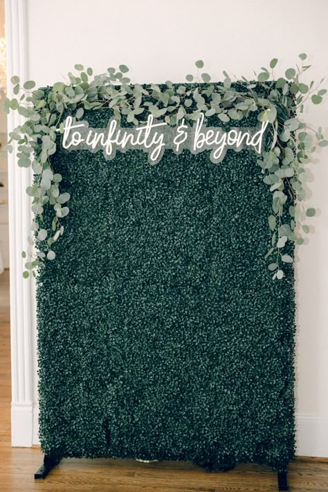 “To infinity & beyond” neon wedding sign greenery backdrop Greenery Wall With Light Up Sign, Permanent Photo Backdrop, Greenery Background Wedding, Greenery Photo Booth, Ivy Wall Photo Backdrop, Greenery Background Photo Backdrops, Wedding Selfie Wall, Diy Greenery Wall Backdrop, Greenery Wall With Neon Sign