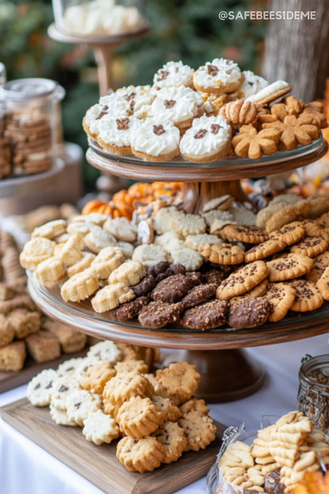 A Thanksgiving dessert table with an assortment of cookies displayed on wooden tiered trays and rustic platters, featuring chocolate-dipped cookies, sugar cookies, and festive fall-themed treats. "We may earn a small commission from your purchase. Assorted Cookie Tray, How To Display Cookies, Cookie Platters Display, Farmhouse Ottoman, Thanksgiving Dessert Table, Helpful Products, Platter Display, Centerpiece Candle Holder, Vintage Centerpiece