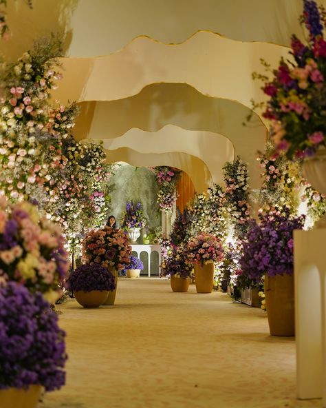 Step into a dreamlike setting where elegance meets natural beauty. Our wedding decor theme, featuring lilac, gold, and lush greenery, transforms the venue into a romantic haven. Lilac florals bring a soft, romantic touch, while gold accents add a touch of luxury and sophistication. The vibrant greenery ties everything together, creating a serene and enchanting atmosphere. From the breathtaking ceremony arch adorned with cascading blooms to the elegantly set tables with gold-rimmed plates and ... Entry Arch, Rimmed Plates, Event Entrance, Arch Decor, Mother Birthday, Ceremony Arch, Creative Idea, Lush Greenery, Walkway