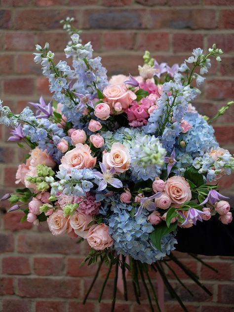 Pastel blush of pink spray roses mixed along side beautiful large heads of pearl coral colour rose and Ice blue delphinium. Including an enlightening range of light blue hydrangea complementing the fluffy tutu shape of Lisianthus and finishing with the touch of lilac colour clematis. Refreshing, colourful and perfect in spring or summer. Image shows size: Statement The flower bouquet will be wrapped in a complimentary wrapping and a bouquet bag with water. To include a vase with your bouquet, kindly select one from our Vase Collection. We kindly request that you order this bouquet at least 1 day in advance to ensure we hand-pick the finest flowers for you. Lilac And Blue Bouquet, Yellow Pink Blue Flower Arrangement, Colorful Hydrangea Bouquet, Pastel Flowers Bouquet, Colourful Flower Arrangements, Pink And Powder Blue Wedding, Blue And Pink Flower Arrangements, Pink And Blue Flower Arrangements, Blue And Pink Bouquet