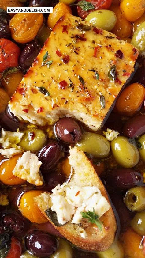 This Baked Feta Recipe is an appetizer that you can prepare in just 5 minutes using a handful of ingredients – grape tomatoes, olives, fresh garlic, olive oil, honey, and dried herbs. Bake it all together with a block of feta cheese until it's warm and soft. Serve it with crostini or pita chips! Baked Feta Cheese, Baked Feta Recipes, Baked Berry Feta, Roasted Olives Appetizer, Feta And Olive Appetizer, Baked Feta Appetizer With Tomatoes, Baked Feta And Olives Recipe, Hot Feta Dip With Marinated Olives, Baked Feta With Olives & Sun Dried Tomatoes