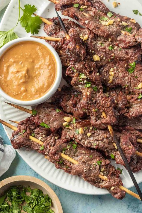 Grilled beef satay with peanut dipping sauce will make a perfect addition to you next barbecue menu. These simple skewers are marinated in a flavorful mix, grilled until tender then drizzled in a sweet and spicy peanut sauce. These skewers are a crowd-pleaser that will impress even the pickiest eaters. Beef Satay Recipe, Satay Marinade, Grilled Steak Kabobs, Beef Satay, Dairy Free Appetizers, Peanut Dipping Sauce, Steak Kabobs, Peanut Dipping Sauces, Beef Skewers